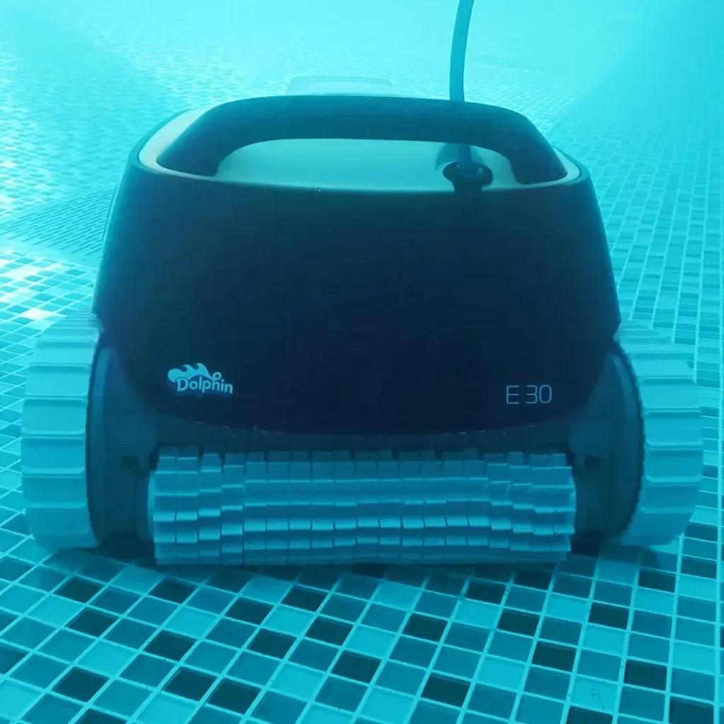 Dolphin E30 en train de nettoyer le fond carrelé d'une piscine, câble flottant relié à la surface