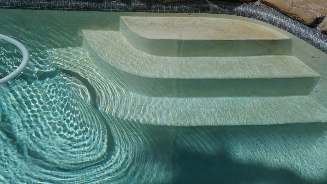 Escalier immergé de trois marches dans une piscine, la zone qu'un robot ne nettoie pas